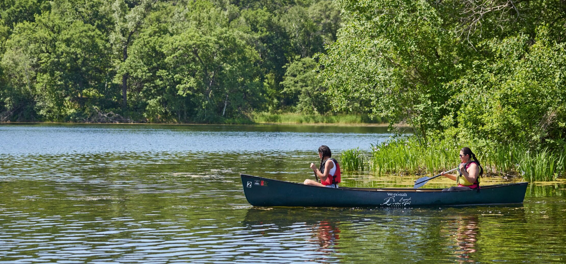 2 canoeists on a lake on summer day